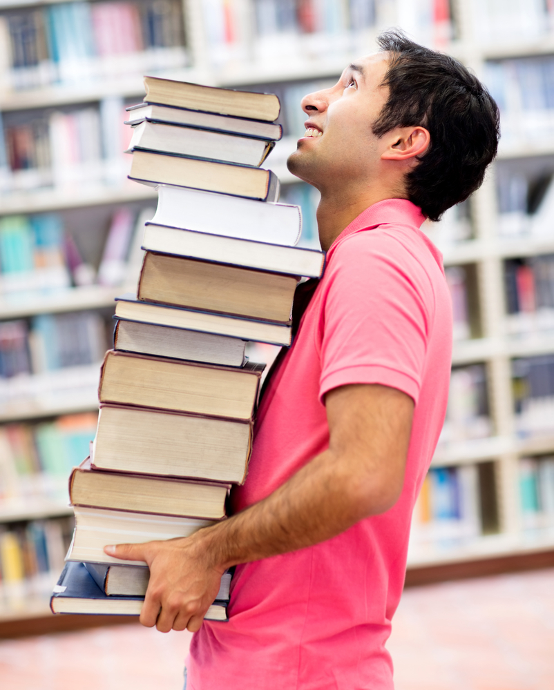 Student at the library carrying heavy books