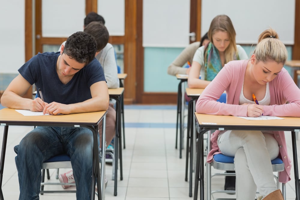 Students taking exams in exam hall in college